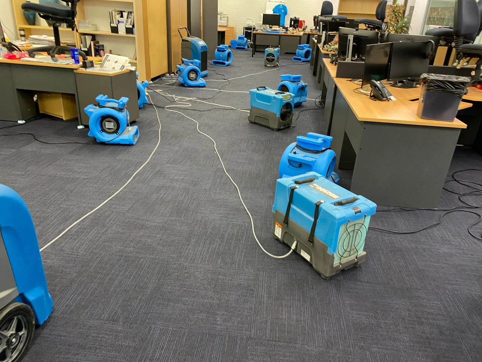 Drying fans positioned around a water-affected office interior