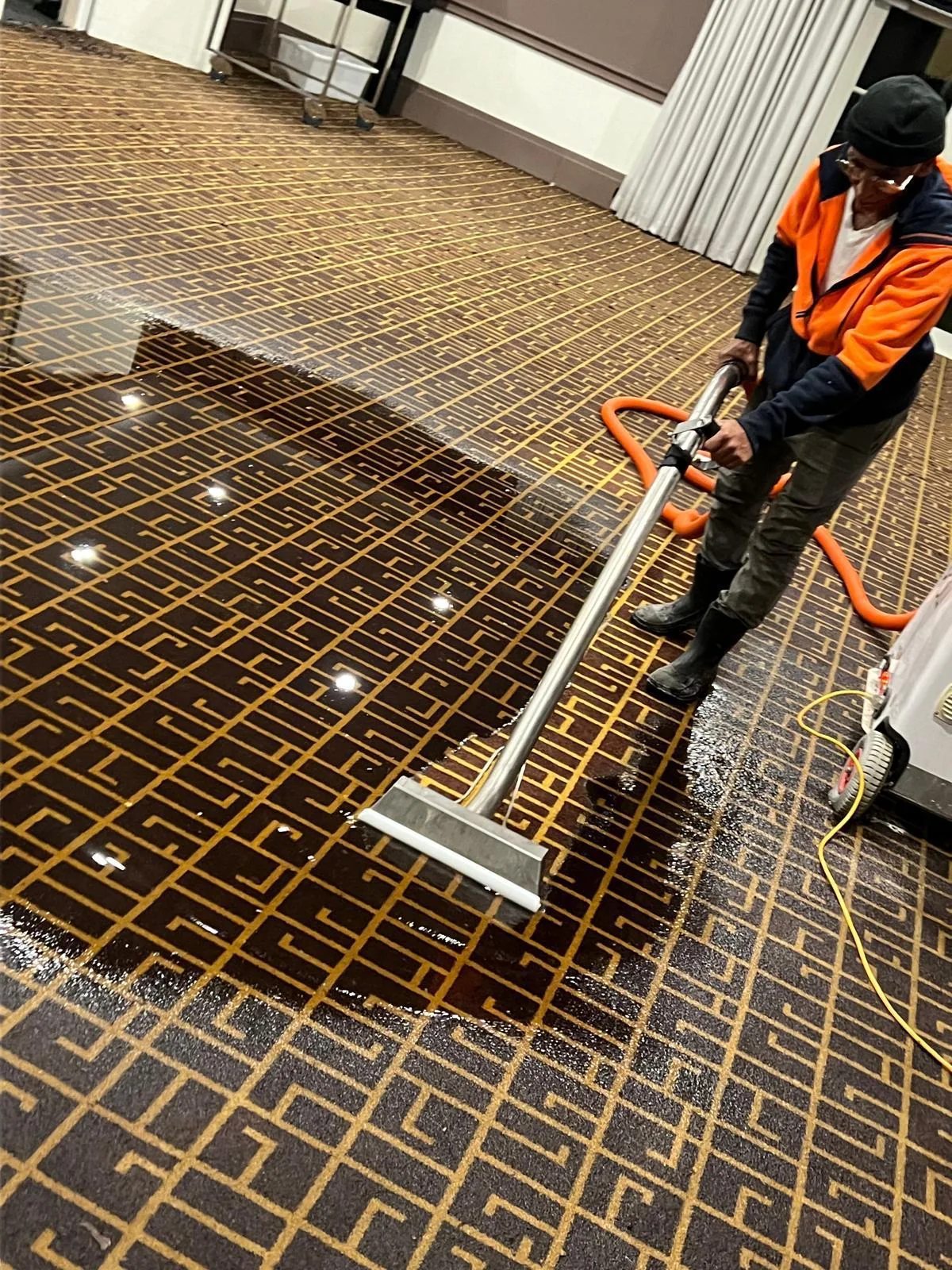 Water extraction equipment being used on a wet floor