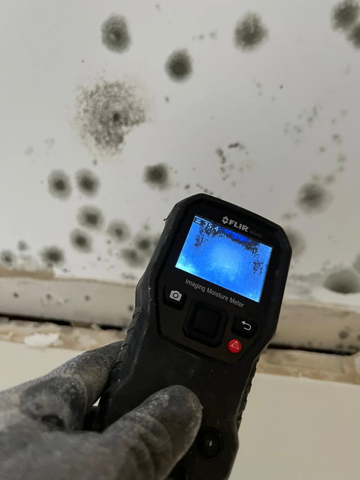 Moisture meter examining marks on a water-damaged ceiling