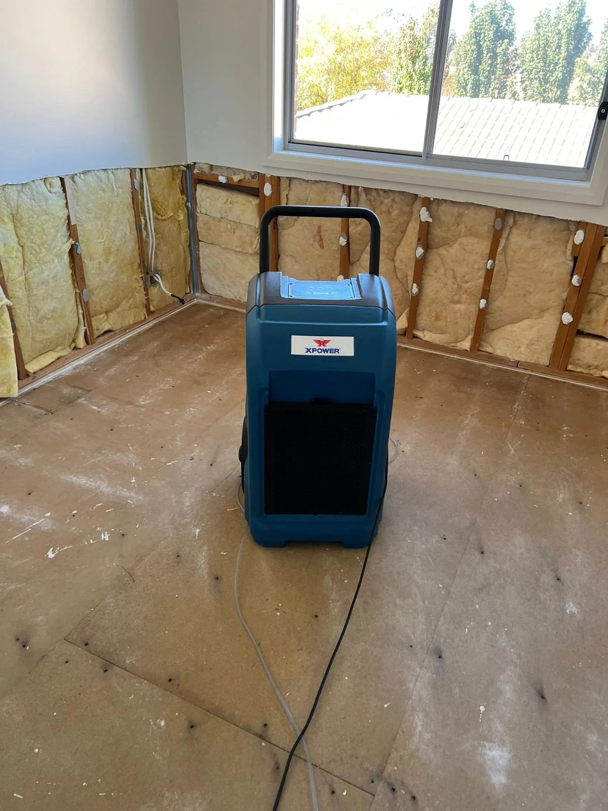 Industrial drying equipment in a room with exposed lower wall sections
